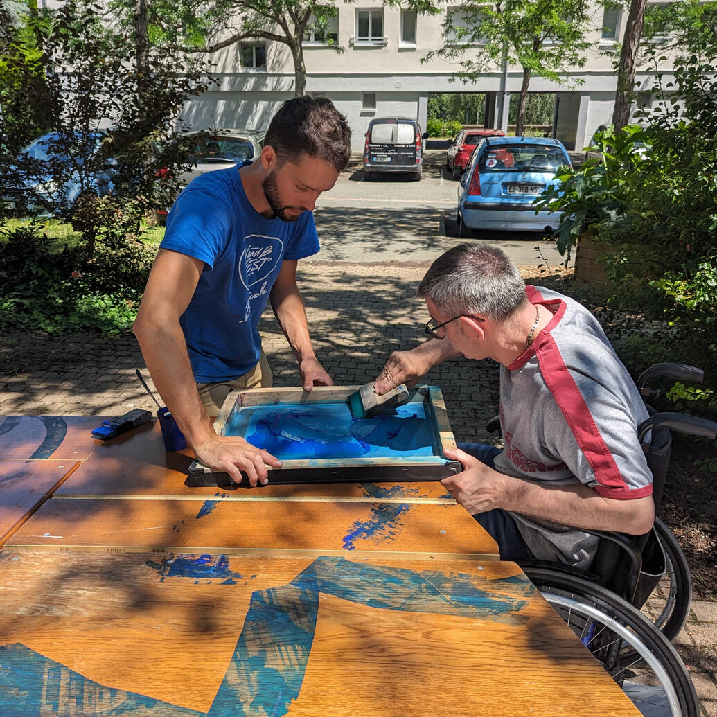 • Belle-Beille — 2023 Un participant sérigraphiant devant la résidence Arceau Partenaires : TALM Angers, le 42, Centre Jacques Tati, asso. du quartier. Commanditaire : Ville d’Angers, département